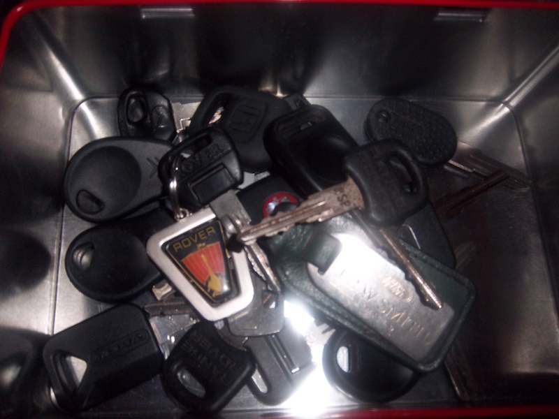 A bunch of car keys in a metal tin